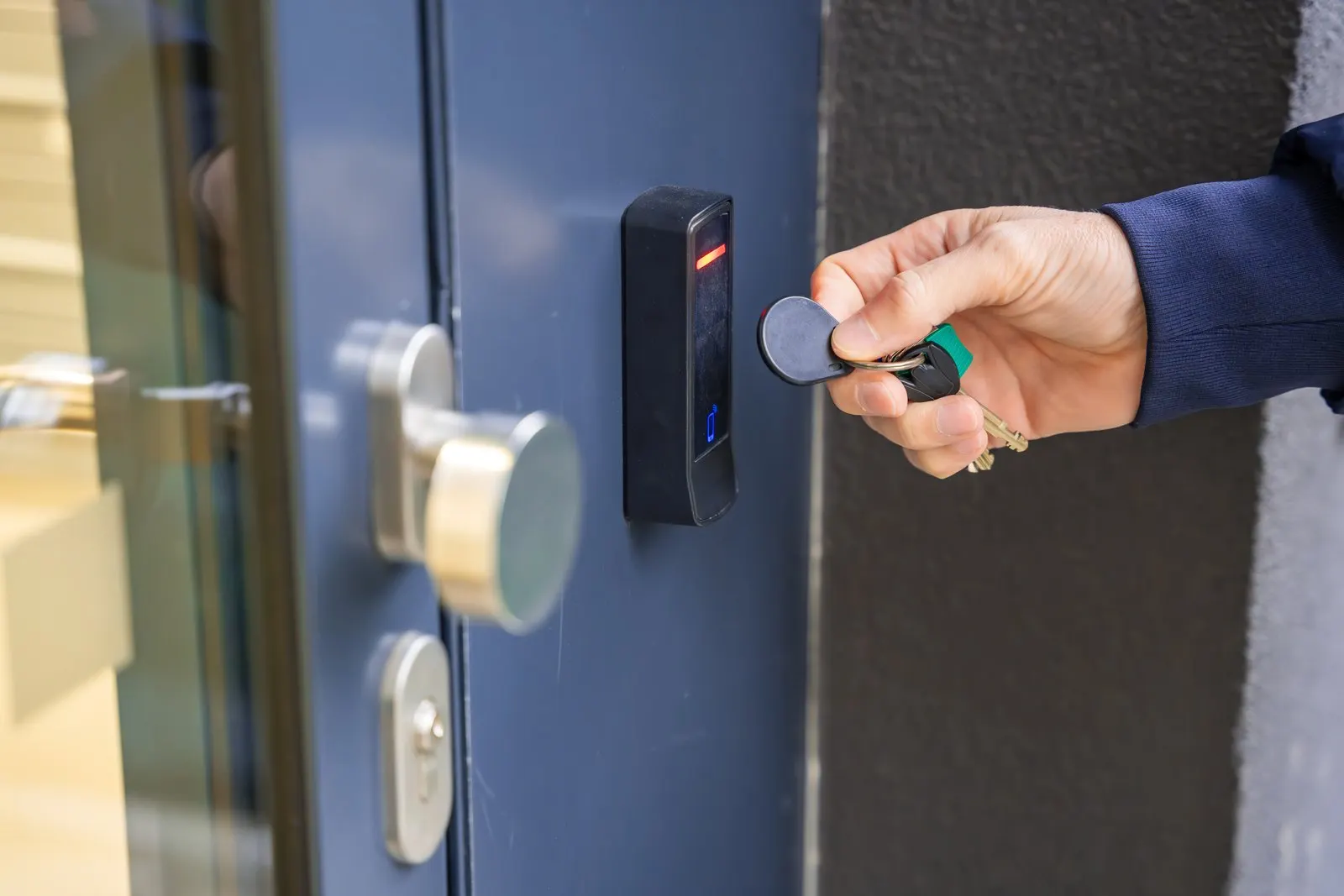Hand mit Transponder vor dem Zutrittsterminal einer Archivtür, Statusanzeige grün